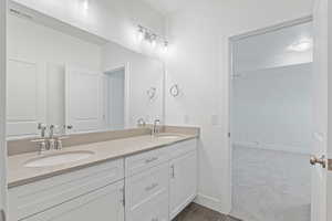 Bathroom with double vanity and tile patterned flooring