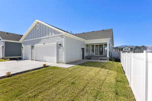 View of front facade with board and batten siding, driveway, an attached garage, a fenced backyard, and a patio area