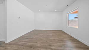 Unfurnished room with wood finished floors and baseboards
