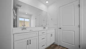 Bathroom with double vanity and wood finished floors