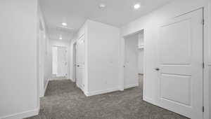 Corridor with dark carpet and recessed lighting