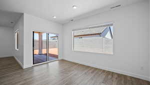 Spare room with wood finished floors and recessed lighting