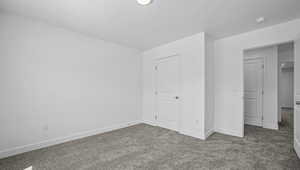 Unfurnished bedroom featuring carpet and baseboards