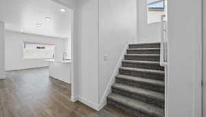 Stairway featuring wood finished floors, recessed lighting, and a textured ceiling