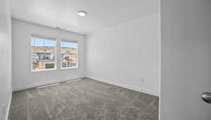 Carpeted empty room featuring baseboards