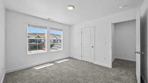 Unfurnished bedroom with carpet floors and baseboards
