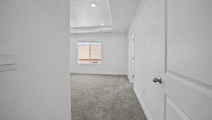 Carpeted empty room featuring baseboards and a tray ceiling
