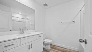 Full bath featuring a shower, wood finished floors, and vanity