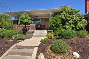 Doorway to property featuring brick siding and a porch