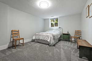 Bedroom with carpet and a textured ceiling