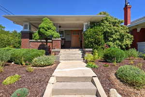 View of front facade featuring brick siding and a porch