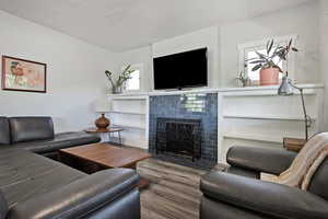 Living area featuring a fireplace, wood finished floors, and a textured ceiling