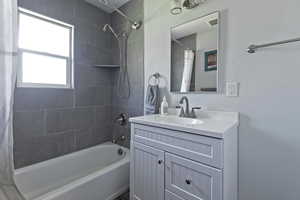 Full bathroom with shower / bathtub combination with curtain and vanity