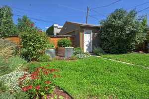 View of grassy yard with a storage unit