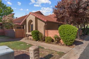 View of property exterior with a tiled roof and stucco siding