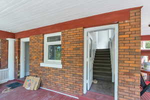 Property entrance with brick siding and a porch