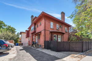 View of front of property featuring a chimney and brick siding
