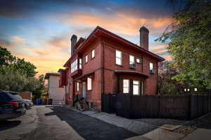 Property exterior at dusk with a chimney and brick siding