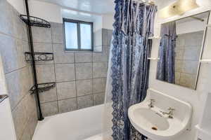 Bathroom featuring shower / tub combo and a sink