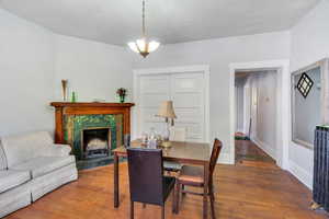 Dining room featuring wood finished floors, a fireplace, and a textured ceiling