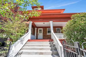View of front of home featuring brick siding and covered porch