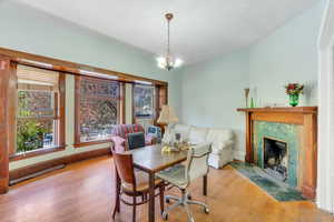 Dining space with a premium fireplace, wood finished floors, and a chandelier
