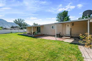 Rear view of property with a deck with mountain view and a patio