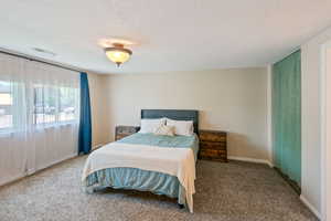 Bedroom with carpet floors and a textured ceiling
