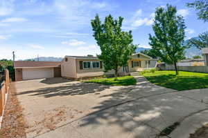 View of front of property featuring concrete driveway, a mountain view, and a garage