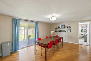 Dining space with light wood-style flooring and a textured ceiling