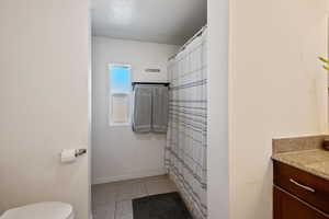 Full bathroom featuring vanity, tile patterned flooring, a textured ceiling, and a shower with shower curtain