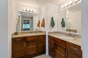 Bathroom featuring two vanities, tile patterned floors, and a ceiling fan