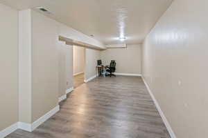 Unfurnished office with a textured ceiling and wood finished floors