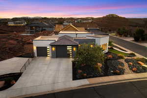 View of front facade featuring a garage, stucco siding, a residential view, concrete driveway, and a tile roof
