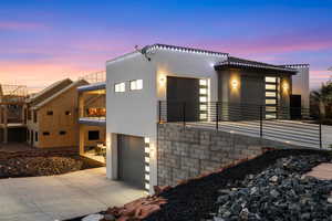 Contemporary home featuring a balcony, stucco siding, concrete driveway, and an attached garage