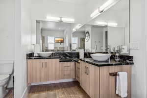 Bathroom with double vanity and wood finished floors