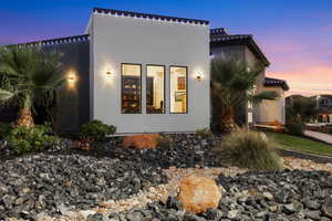Property exterior at dusk with stucco siding and a tile roof