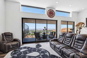 Living area with a mountain view, plenty of natural light, a textured ceiling, and wood finished floors