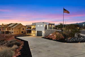 Contemporary home with a balcony, driveway, a garage, and stucco siding