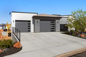 View of front of property featuring stucco siding, an attached garage, and concrete driveway
