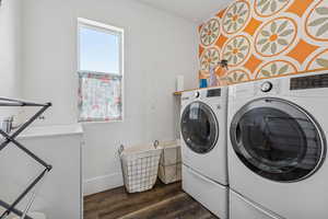Laundry room featuring washing machine and clothes dryer and dark wood finished floors
