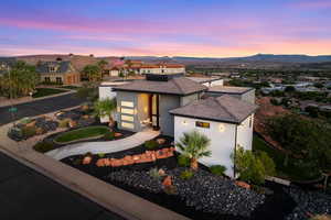 View of front of property featuring stucco siding, a residential view, a tiled roof, a garage, and concrete driveway