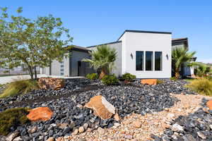 View of front of property featuring an attached garage and stucco siding