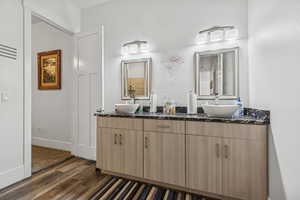 Full bathroom with double vanity and wood finished floors