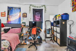 Bedroom featuring wood finished floors and a wood stove
