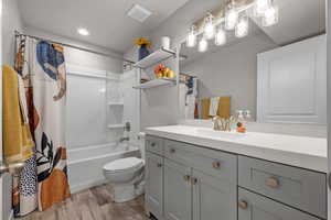 Full bathroom with wood finished floors, vanity, and shower / bathtub combination with curtain
