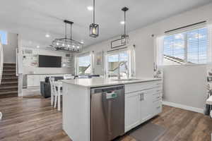 Kitchen featuring dishwasher, a center island with sink, white cabinetry, wood finished floors, and recessed lighting