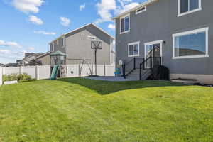 Rear view of property with a playground and stucco siding