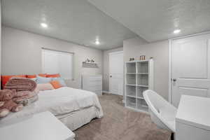 Carpeted bedroom featuring a textured ceiling and recessed lighting