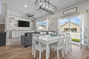 Dining area featuring light wood-style flooring, stairs, a ceiling fan, recessed lighting, and a textured ceiling